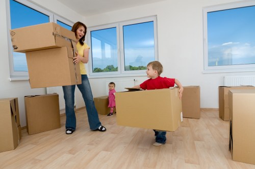 Professional movers carrying furniture through a Kennington flat entrance