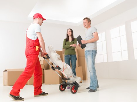 Movers handling boxes and furniture in a Kennington flat removal